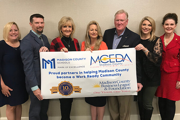 MCEDA staff holding banner for Grant Award