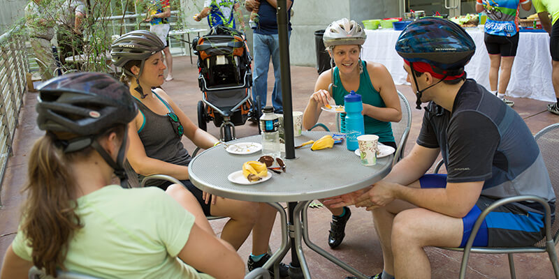 Bicyclists sitting at a table talking