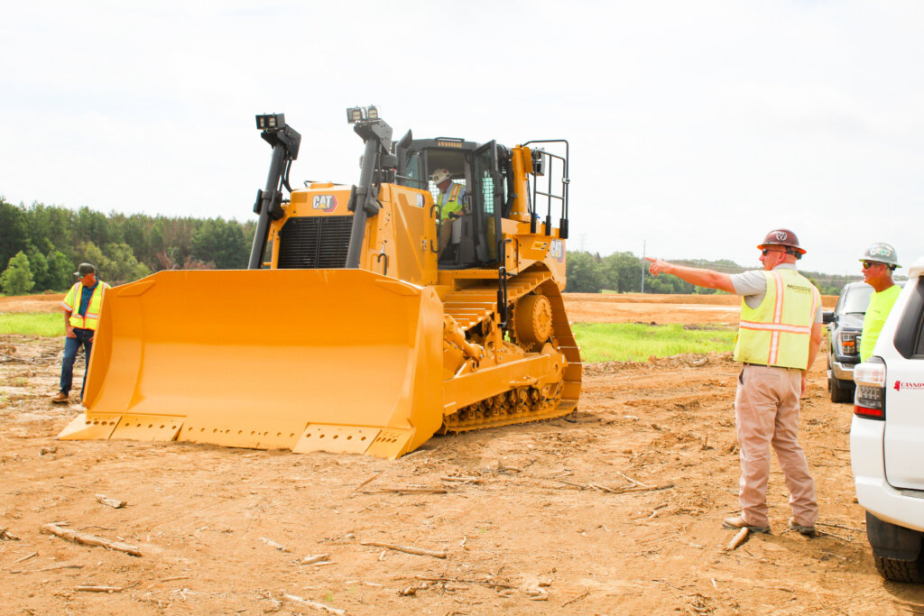 Workers pointing at machine